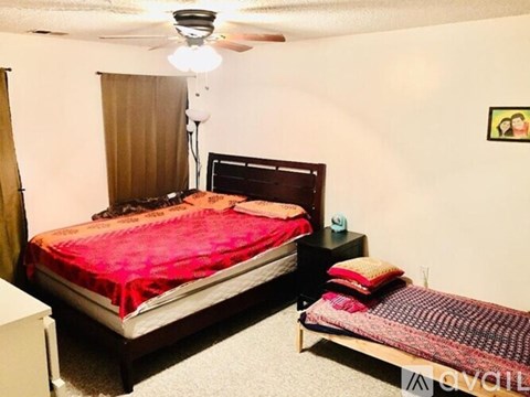 A bedroom with a bed and a small bed on the side.