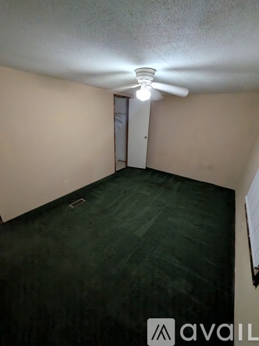 A room with a ceiling fan and a door.