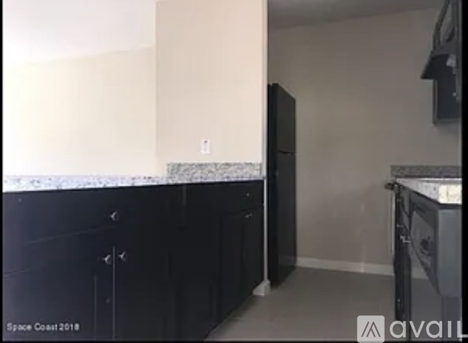 A kitchen with black cabinets and a white countertop.