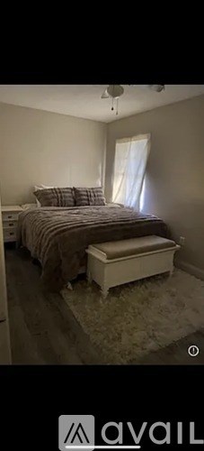 A bedroom with a bed and a bench.