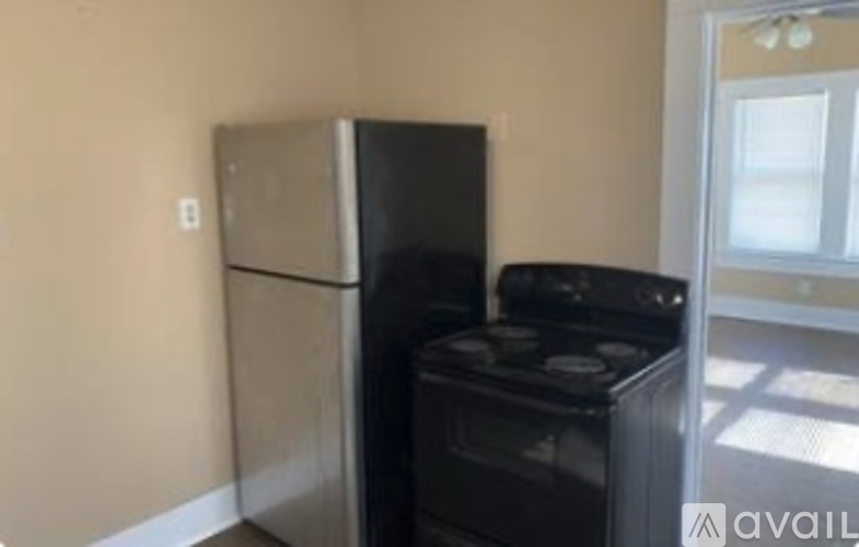 A black refrigerator and black stove in a kitchen.