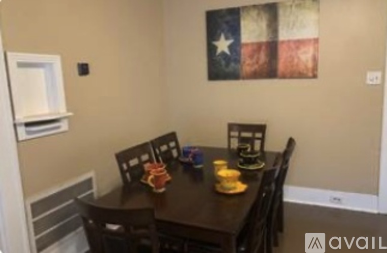 A dining room with a table set for four and a flag hanging on the wall.