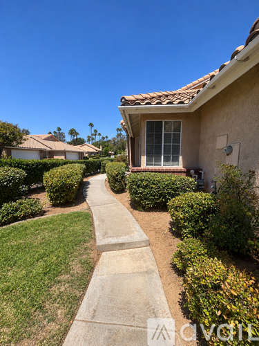 A house with a red tile roof and a well-maintained lawn.