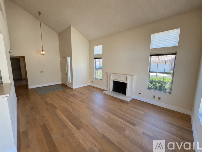 A living room with a fireplace and a large window.