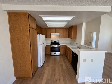 A kitchen with wooden cabinets and a white refrigerator.