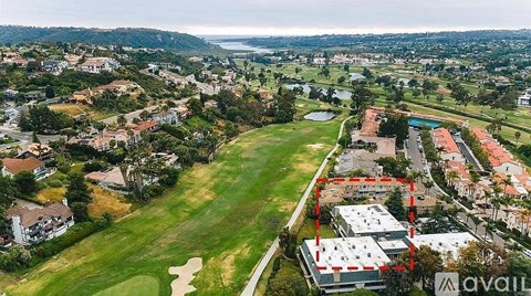 A golf course is surrounded by houses and buildings.