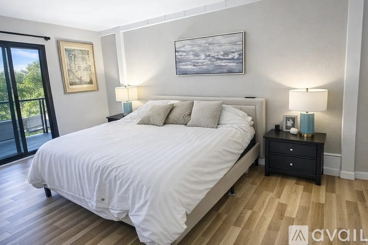 A bedroom with a large bed and a painting on the wall.