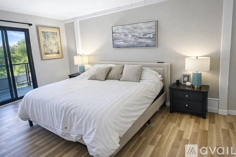 A bedroom with a large bed and a painting on the wall.