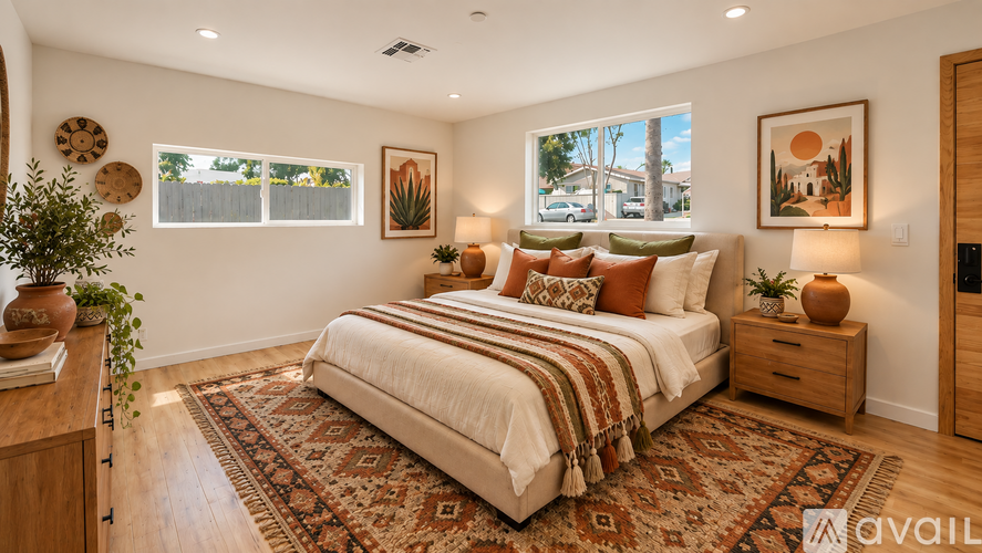 A bedroom with a large bed, a rug, and a wooden dresser.