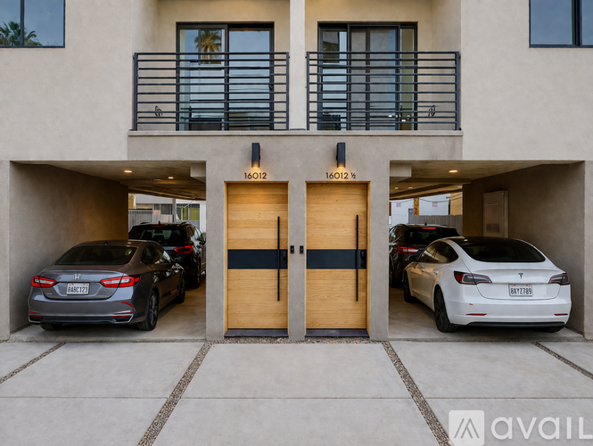 Two cars are parked in front of a building with two doors.