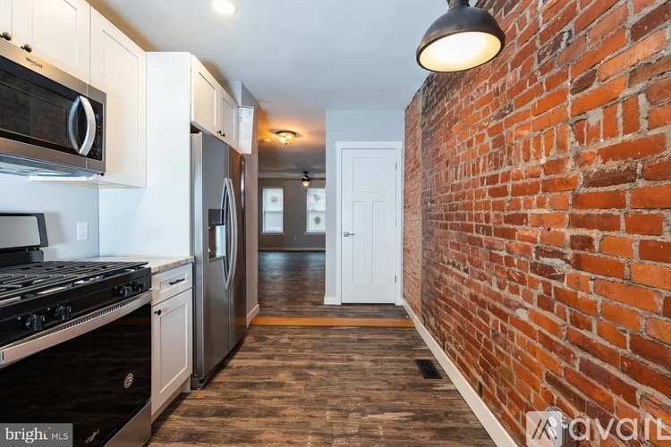 A kitchen with a stove top oven and a refrigerator.