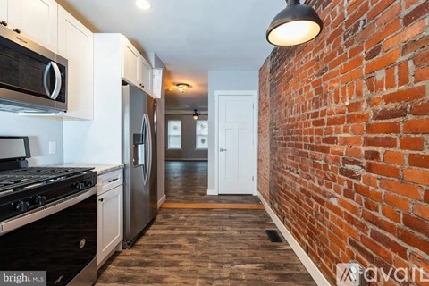 A kitchen with a stove top oven and a refrigerator.