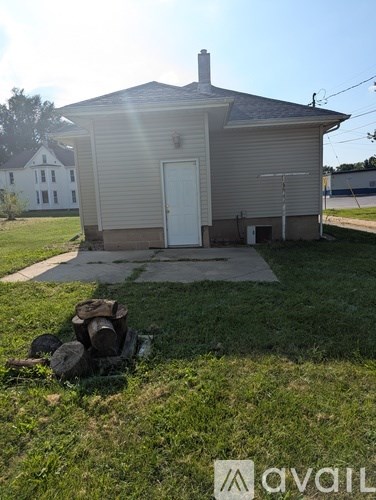 A small house with a white door and a chimney.