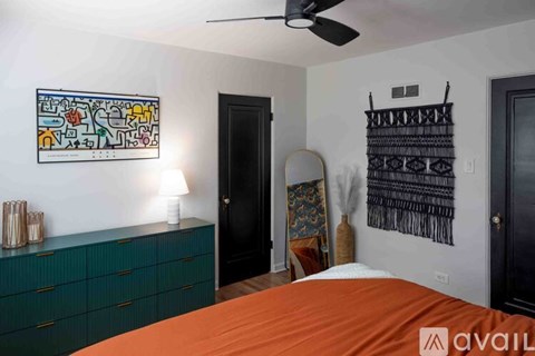 A bedroom with a bed, a dresser, and a painting on the wall.