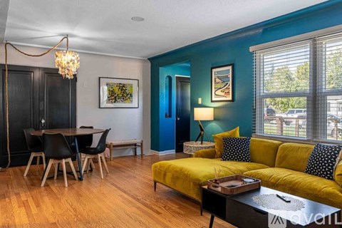 A living room with a yellow sofa and a wooden coffee table.