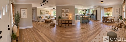 A large open living room with a kitchen in the background.