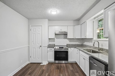 A kitchen with white cabinets and a stainless steel oven.