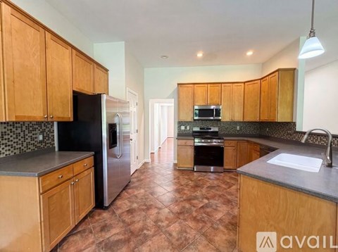 A kitchen with wooden cabinets and a black fridge.