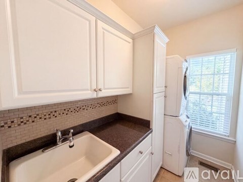 A kitchen with white cabinets and a black countertop.