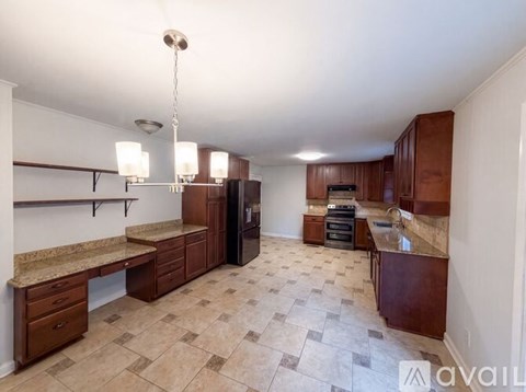 A kitchen with brown cabinets and a tiled floor.