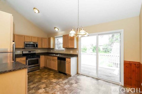 A kitchen with wooden cabinets and a black granite countertop.