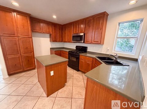 A kitchen with wooden cabinets and a stainless steel island.
