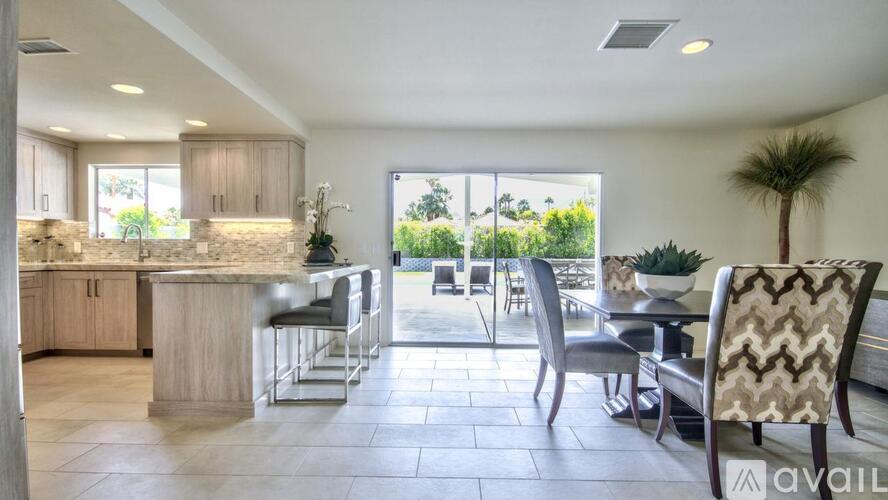 A kitchen with a bar area and a dining table with chairs.