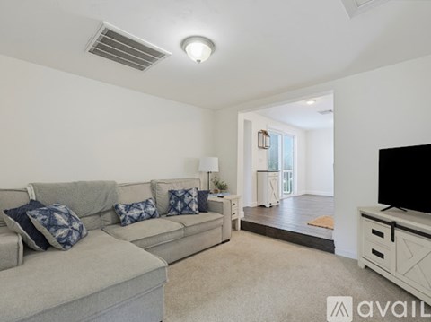 A living room with a grey couch and a television.