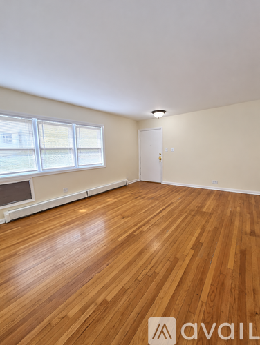 A room with wooden flooring and a window.