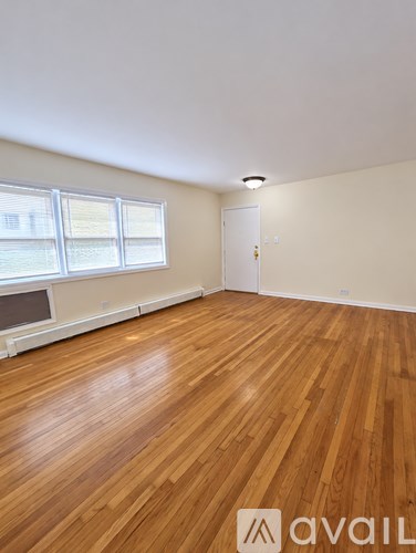 A room with wooden flooring and a window.