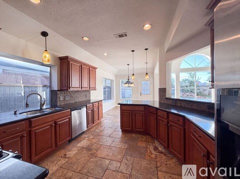 A kitchen with brown cabinets and a tile floor.