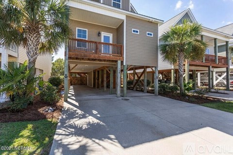 A sunny day at a residential complex with apartment buildings and palm trees.