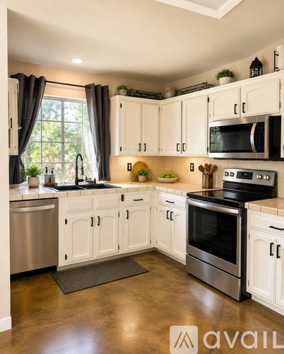 A kitchen with white cabinets and stainless steel appliances.