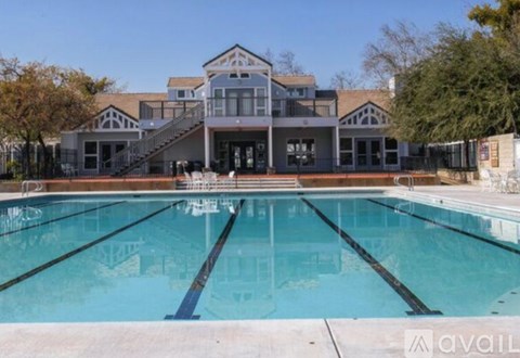 A large swimming pool in front of a multi-story building.