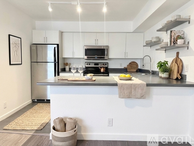 A kitchen with white cabinets and a black countertop.