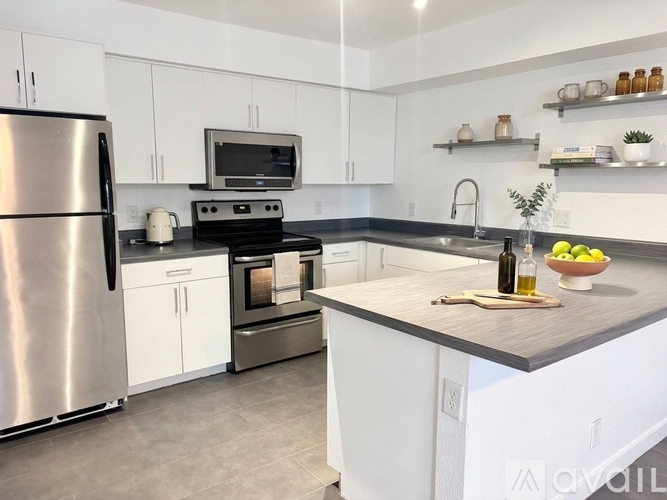 A modern kitchen with white cabinets and a stainless steel refrigerator.