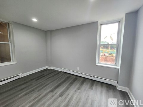 A room with grey walls and a window overlooking a playground.
