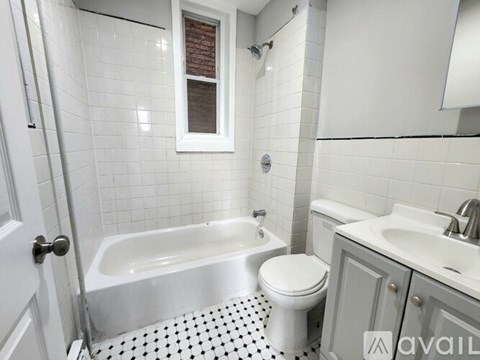 A white bathroom with a black and white floor.