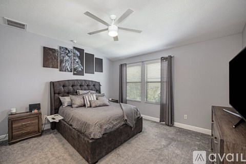 A bedroom with a large bed and a ceiling fan.