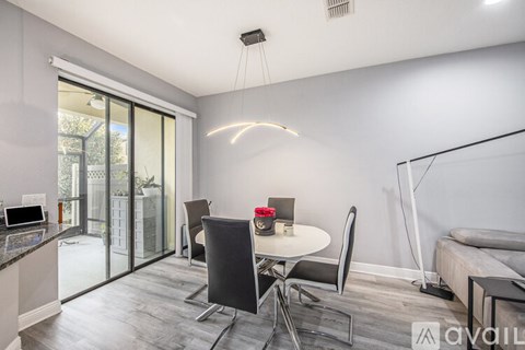 A modern dining room with a glass table and chairs.