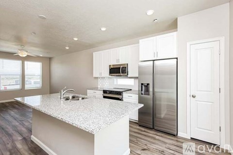 A kitchen with white cabinets and a granite countertop.