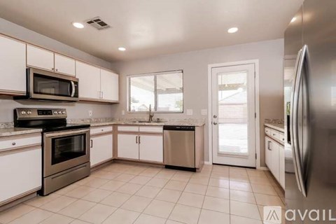 A kitchen with white cabinets and stainless steel appliances is available for rent.