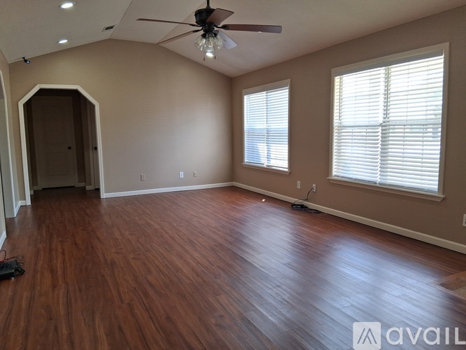 A room with wooden flooring and a ceiling fan.