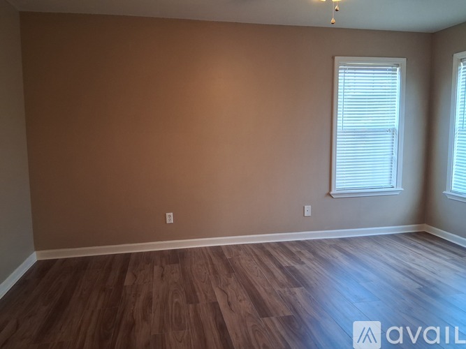 A room with brown walls and wooden flooring is available.