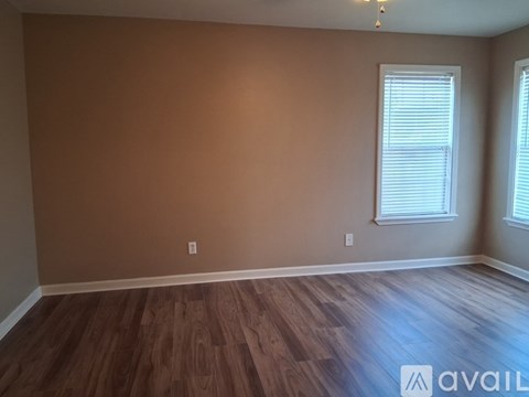 A room with brown walls and wooden flooring is available.
