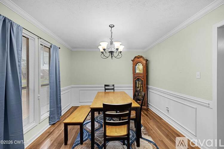 A dining room with a wooden table and chairs.