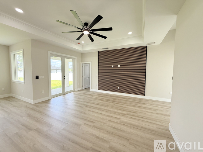 A spacious room with a ceiling fan and lighting fixtures.