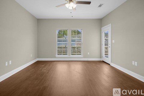 A room with a ceiling fan and a window with a view of a building.