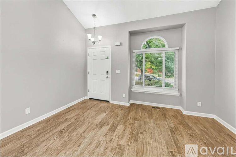 A room with wooden flooring and a white door.