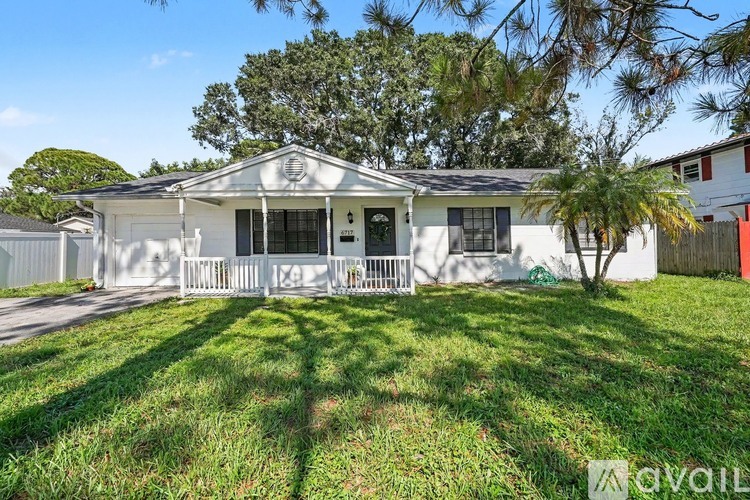 A white house with a porch and a fence.